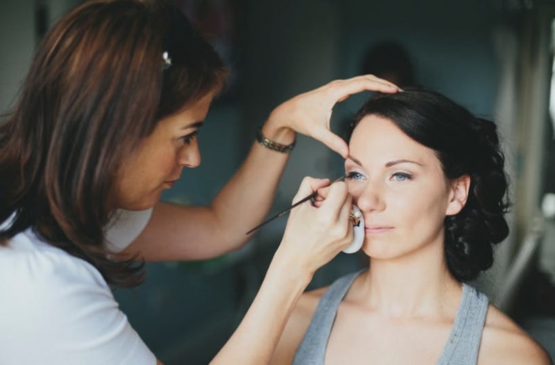 Make up artist putting sustainable make up on bride to be on wedding day