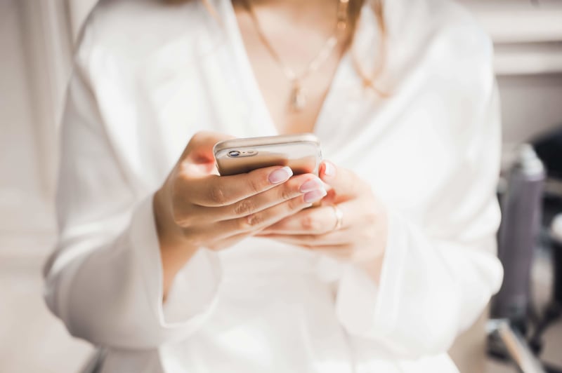 Woman holding phone to contact her wedding suppliers