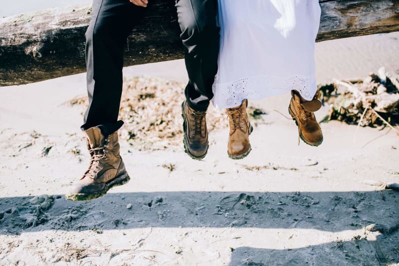 Wedding couple sitting on a log at the beach