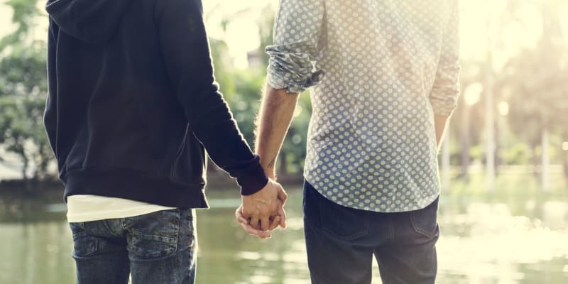 Couple holding hands while looking at a lake