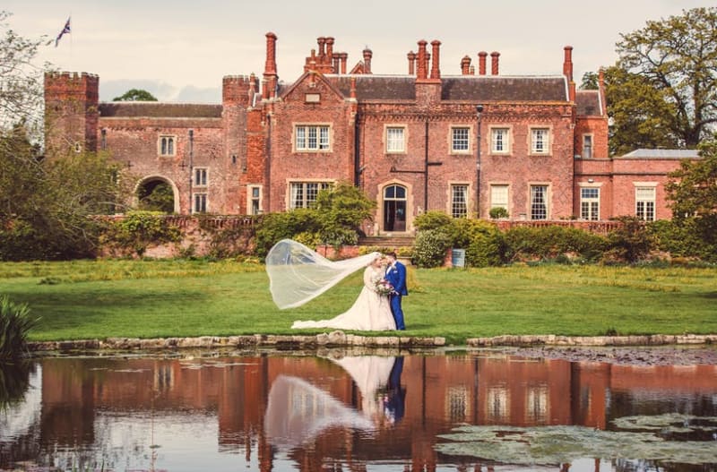 Married couple standing in front of Hodsock Priory wedding venue in Nottinghamshire, UK