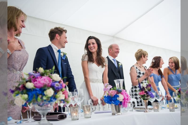 Bridebook.co.uk- bride groom and wedding party standing up at the top table