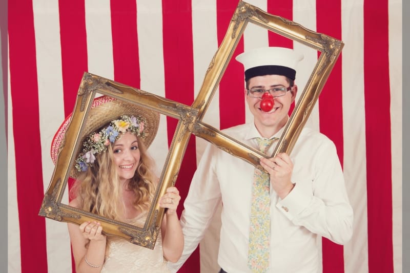 Bridebook.co.uk- bride and groom with props in photobooth
