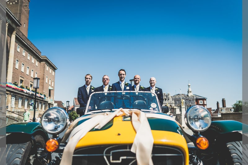 Bridebook.co.uk- groom and ushers in yellow sports car