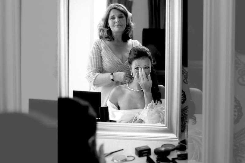 Bridebook.co.uk- mother and bride tearing up reflection in the mirror