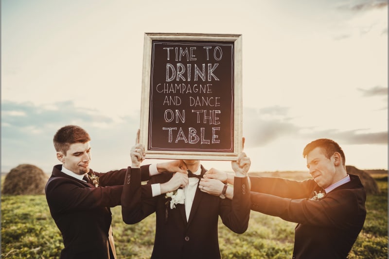 Bridebook.co.uk Groom and best men holding dance floor sign