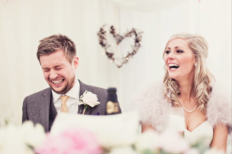 Bridebook.co.uk- groom cringing bride laughing during the speeches
