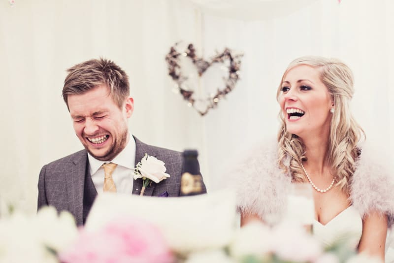 Bridebook.co.uk- groom cringing bride laughing during the speeches