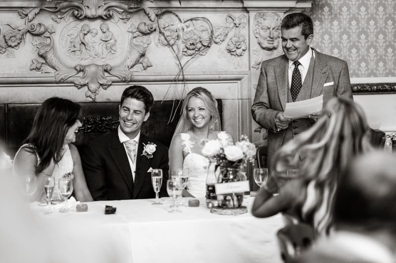 Bridebook.co.uk- father giving speech as groom bride and mother laugh
