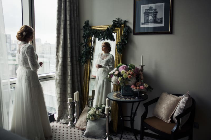 Bridebook.co.uk bride looking into mirror getting ready