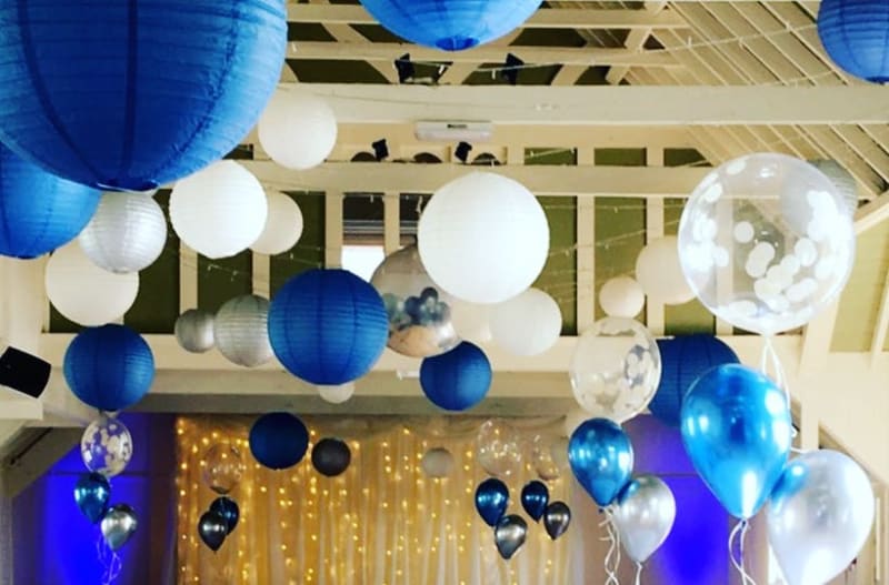 Blue and white custom balloons near the ceiling of wedding venue