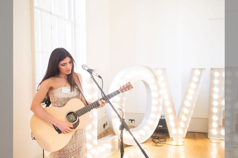 bridebook.co.uk girl with guitar playing at a wedding
