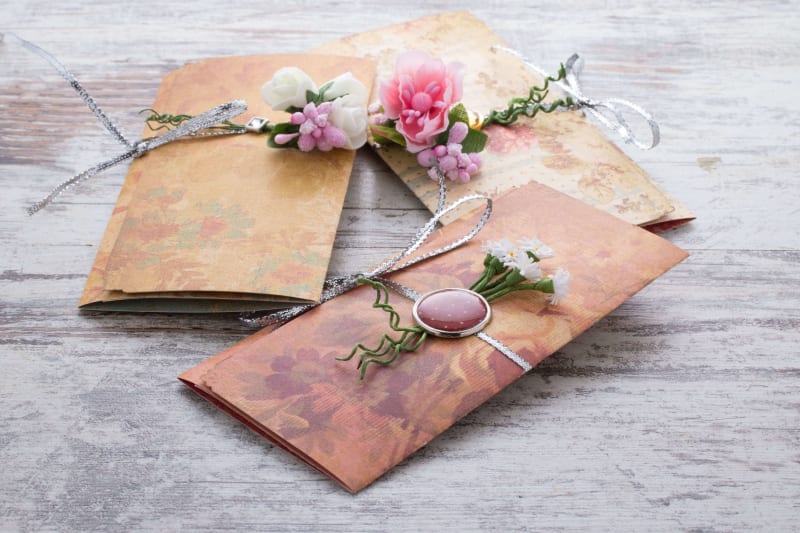 Wedding invitations with flowers presented on a wooden table