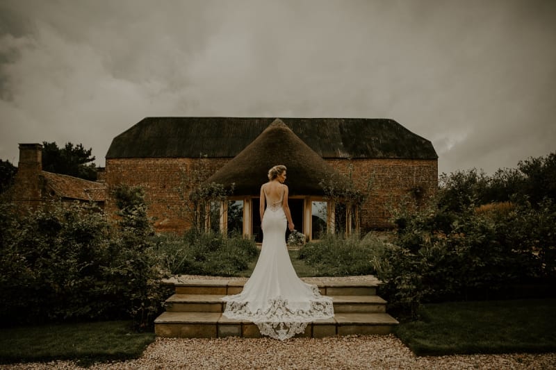 bride stands in front of brickhouse vineyard wedding venue