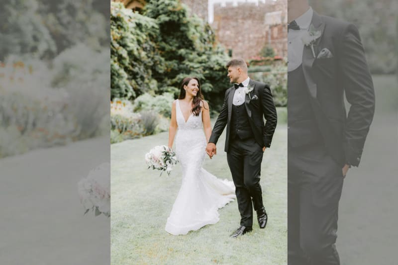 The bride and groom holding hands and smiling at each other.
