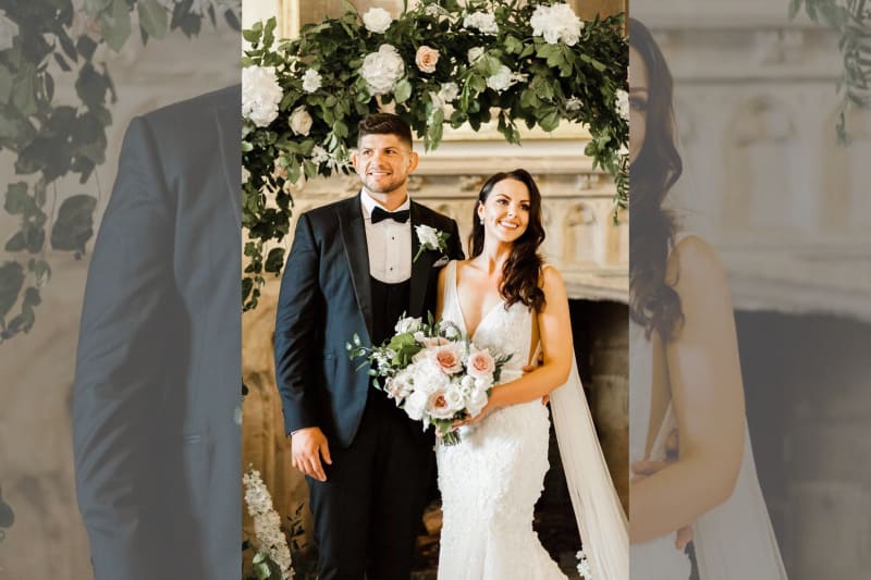 The bride and groom smiling underneath the archway of the ceremony room.
