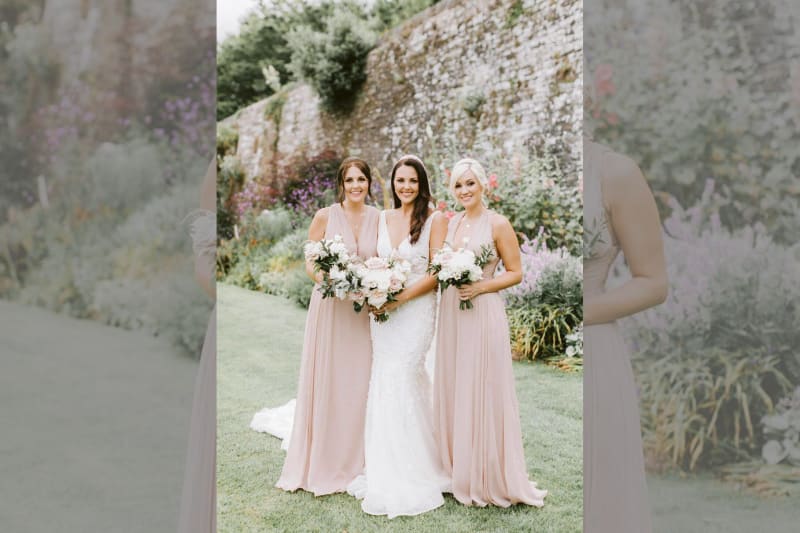 The bride posing with two bridesmaids.