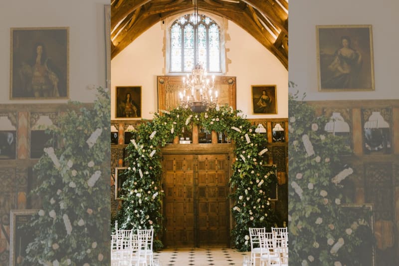 The ceremony room shows an archway covered in white flowers.