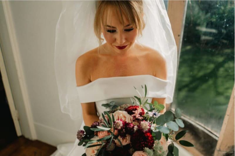 The bride is inside holding a bouquet.