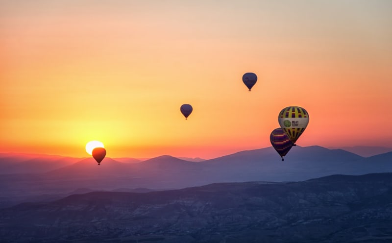 Hot air balloons in the air with a beautiful sunset in the background