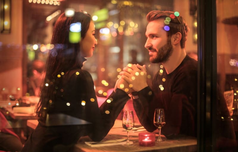 Boyfriend and girlfriend recreating their first date at a restaurant with the boyfriend about to propose to his girlfriend