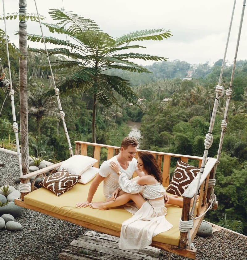 Couple relaxing on swing on holiday