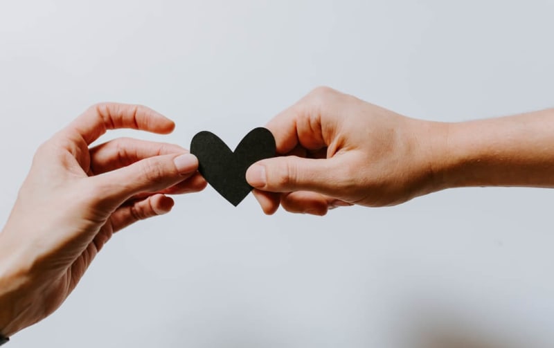 Two hands holding a paper crafted heart 