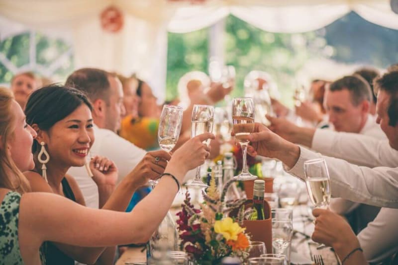 Guests holding champagne glasses and toasting.