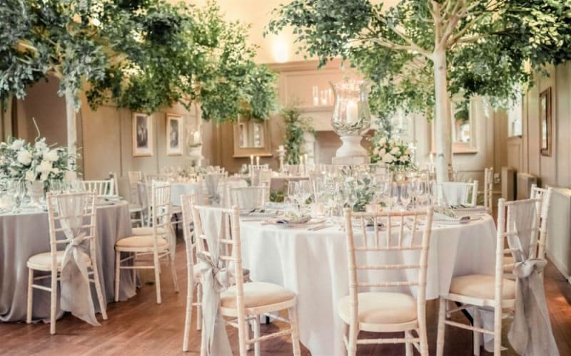 Several white tables for the reception.