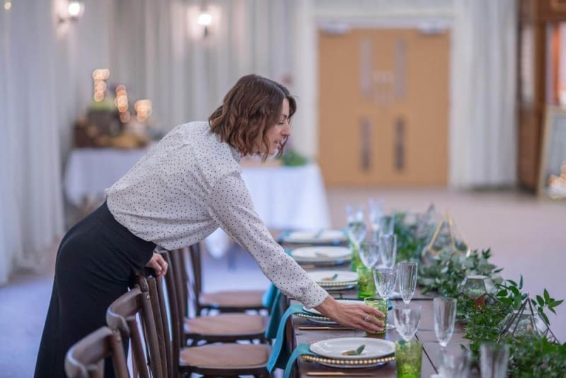 A woman sets the table for the wedding feast.