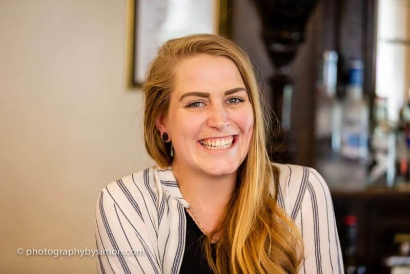 Blonde woman smiling at the camera.