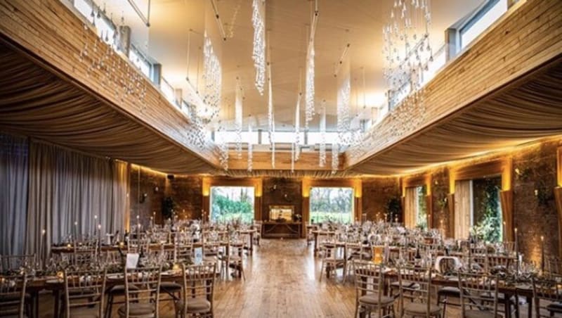 A room set up with chairs, tables and decorations for a wedding reception.