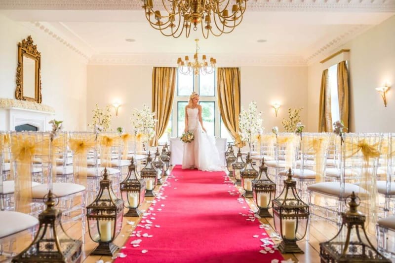 The bride stands at the altar, which is inside the venue itself.