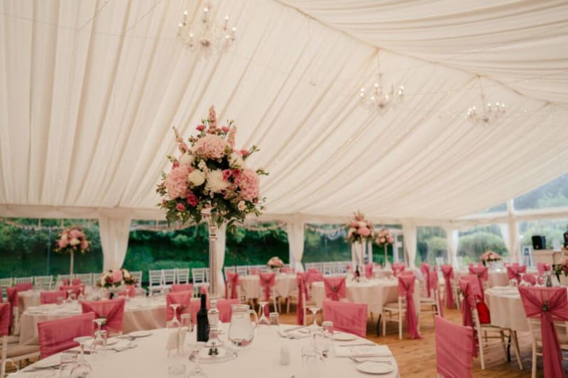 The interior of a tent decorated in white and pink.