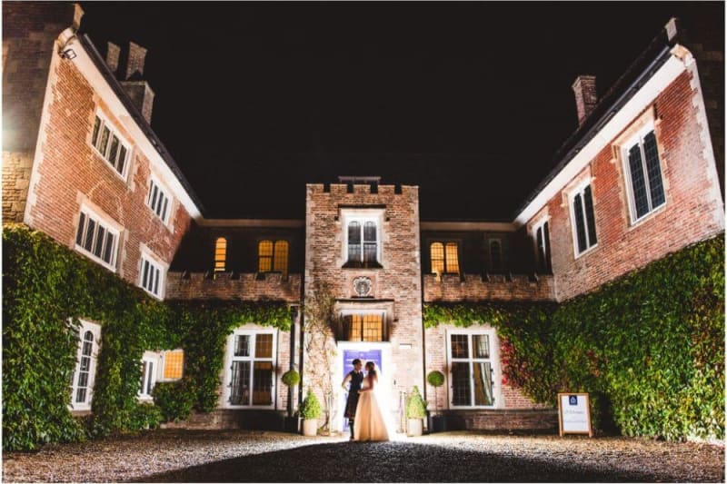 Bride and Groom stand outside the venue at night.