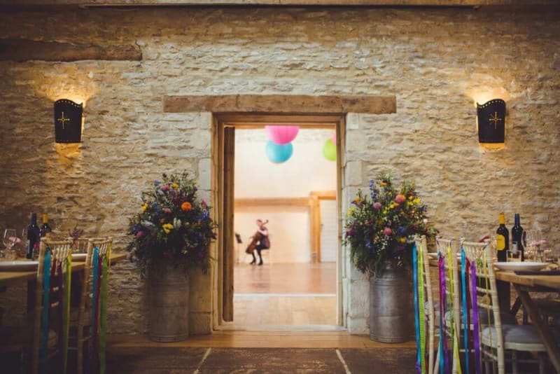 Inside the barn, many colorful decorations are displayed and a person is playing cello in the background.