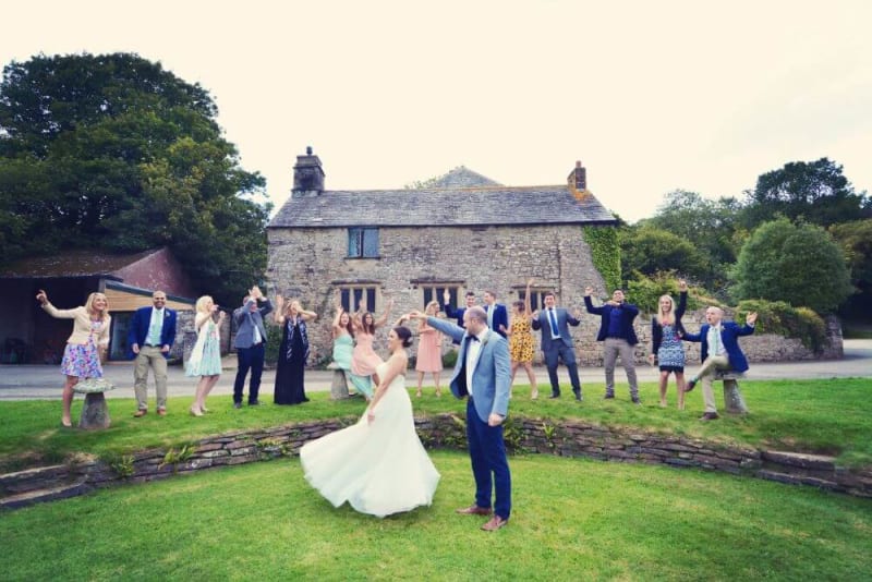 Bride and Groom dancing outside with the guest cheering on.