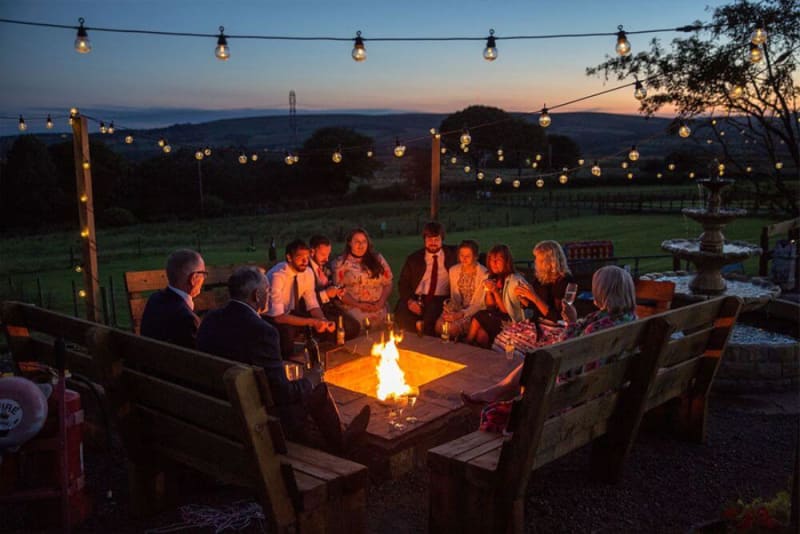 Group of people sitting around a campfire in the evening. 