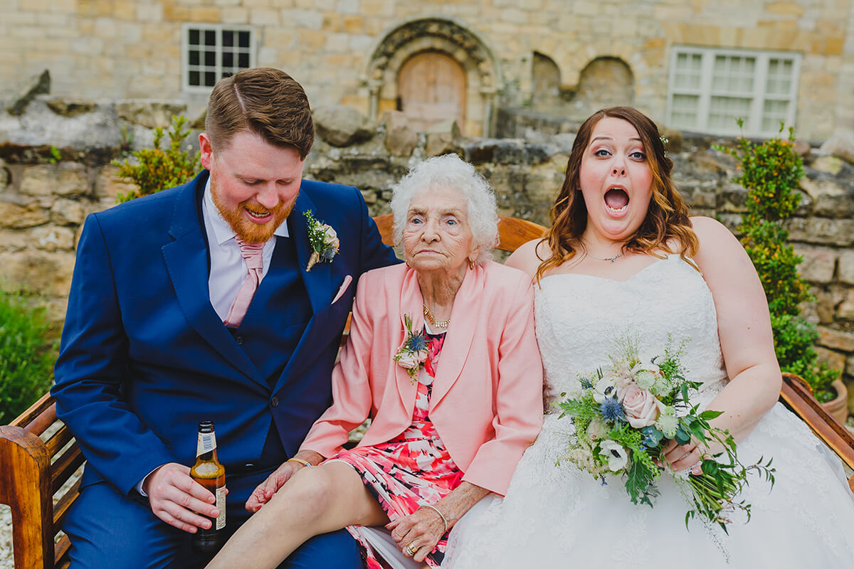 bride groom and grandma pose for a wedding photo