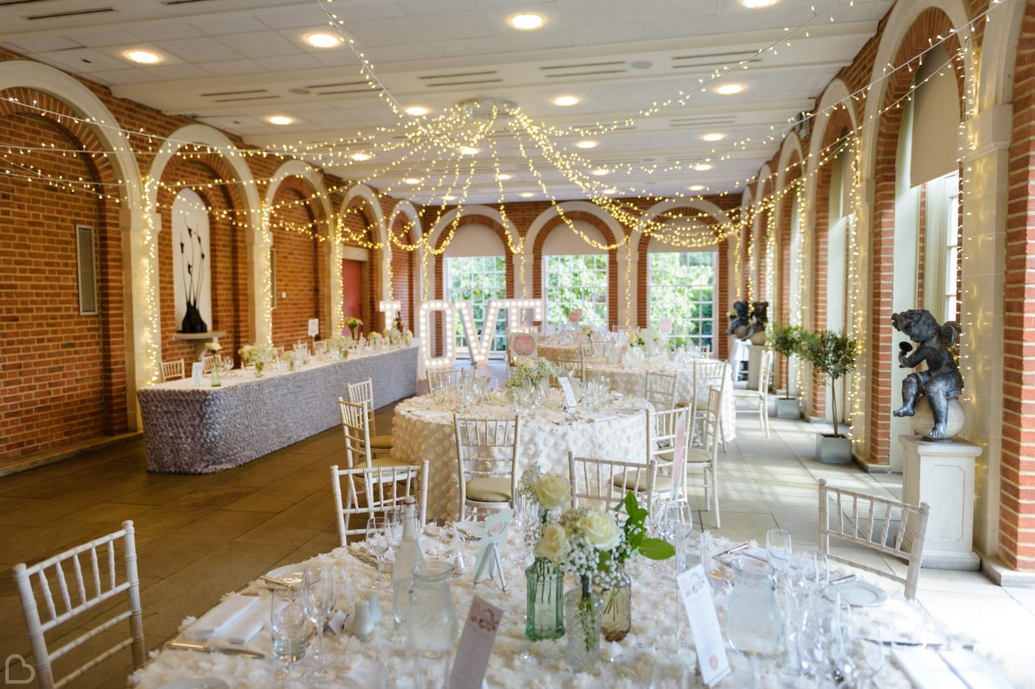 great fosters with fairy lights and tables set for a wedding lunch 