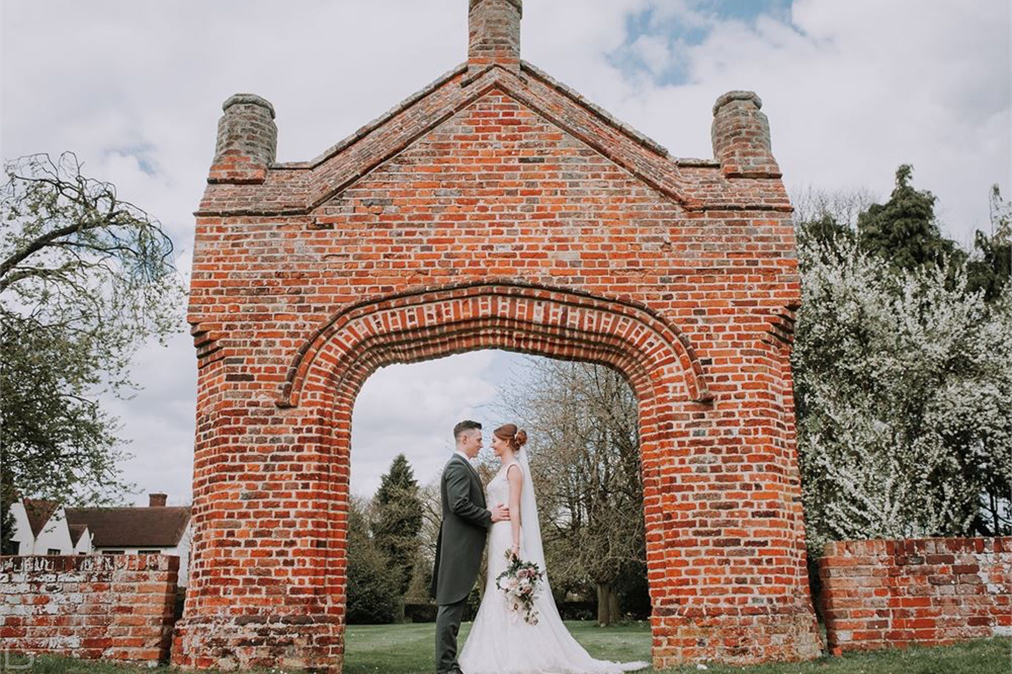 Newlyweds pose in arch at colville hall