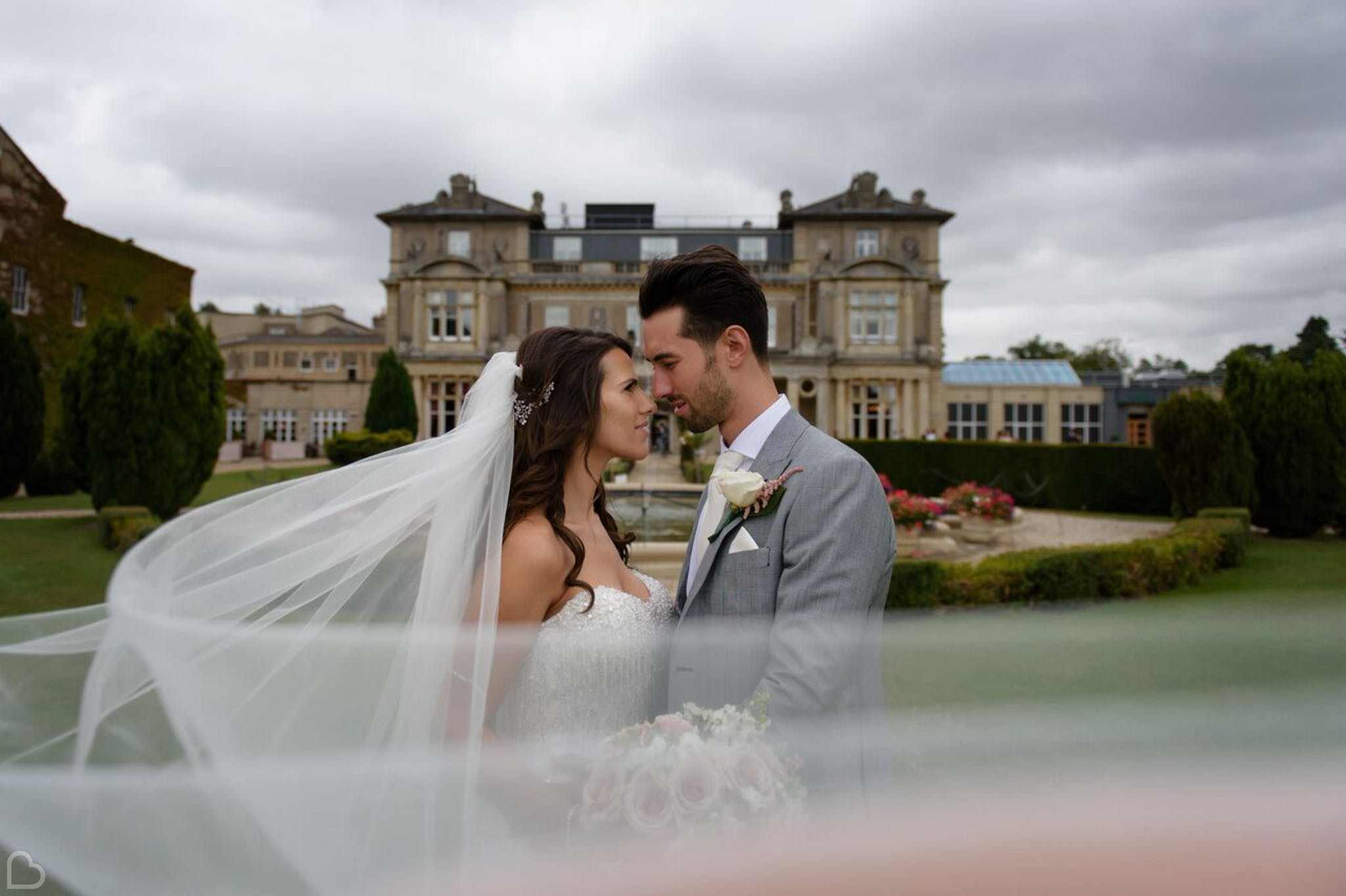 Newlyweds embrace is front of Down Hall Hotel & Spa