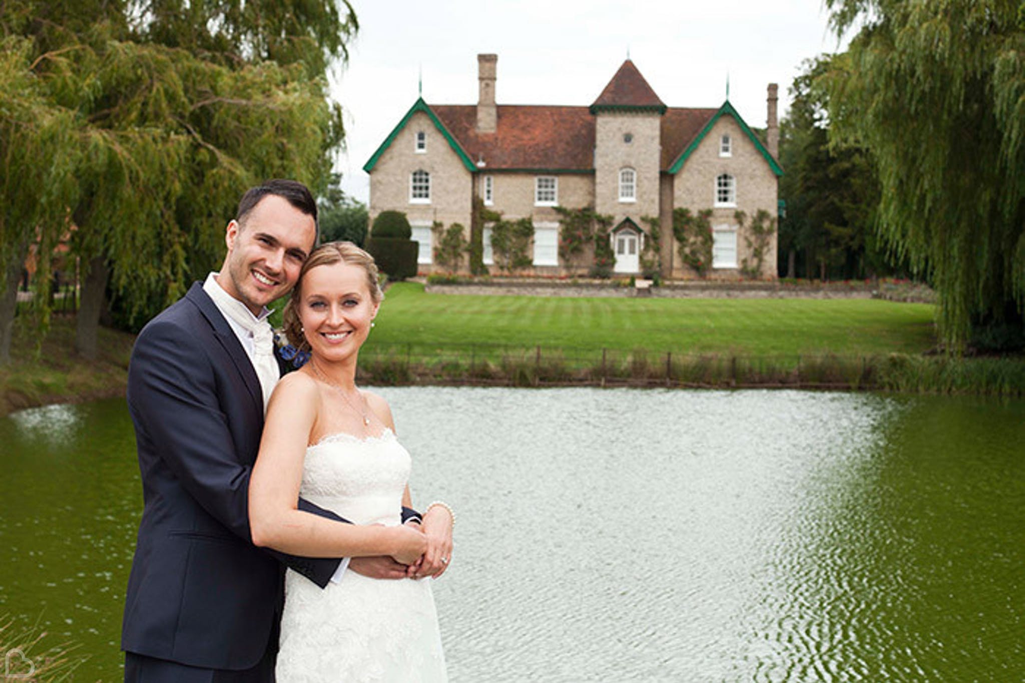 newlyweds pose in front of smeethan hall barn in essex