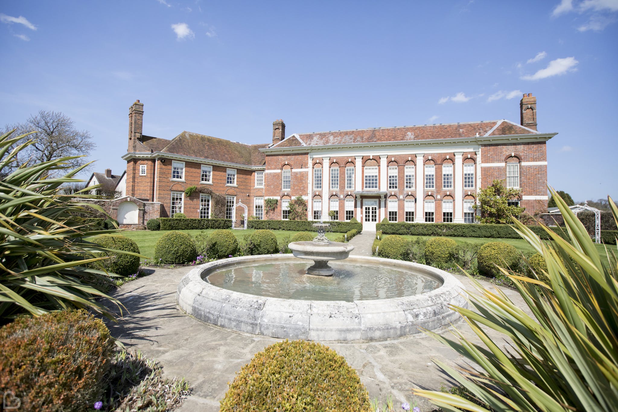 Parklands Quendon Hall fountain and gardens on a sunny day.