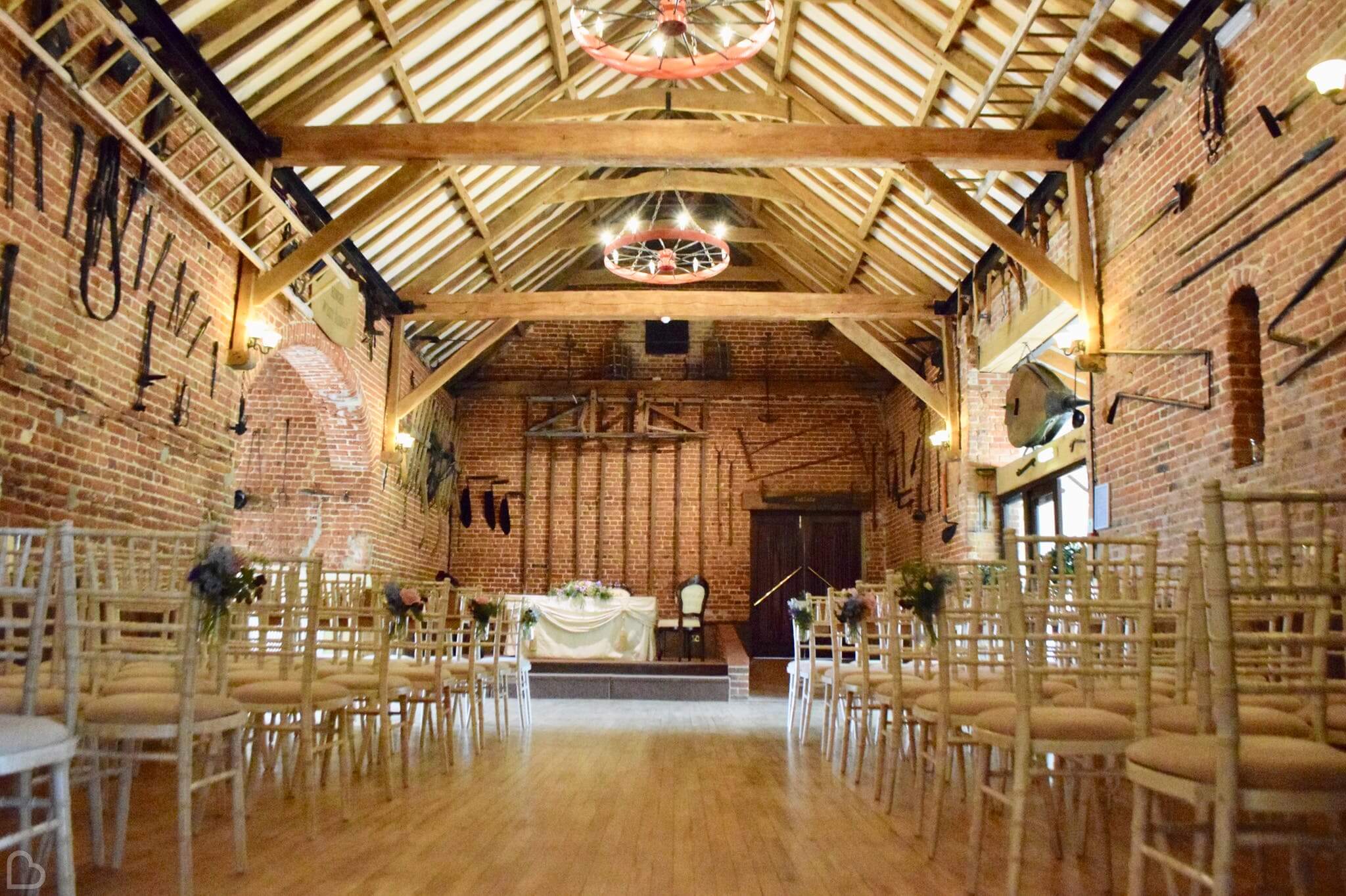 Hunters Hall barn set up with chairs and an altar, for a wedding ceremony. 