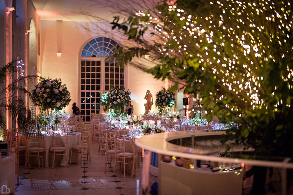 Wedding hall decorated with big flowers and fairy lights at kew gardens wedding venue.