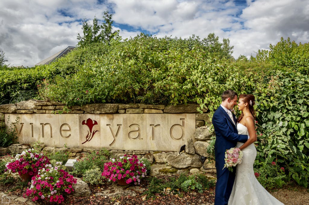 Newlyweds kiss outside the vineyard wedding venue in Berkshire