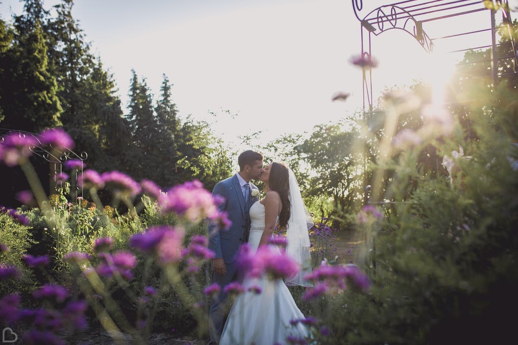 Newlyweds kiss in Hayne House garden.