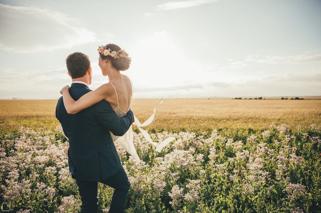 Newlyweds walking along the fields.