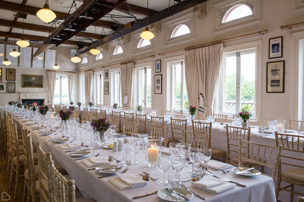 Tables set up inside the London Rowing Club, ready for a wedding lunch.